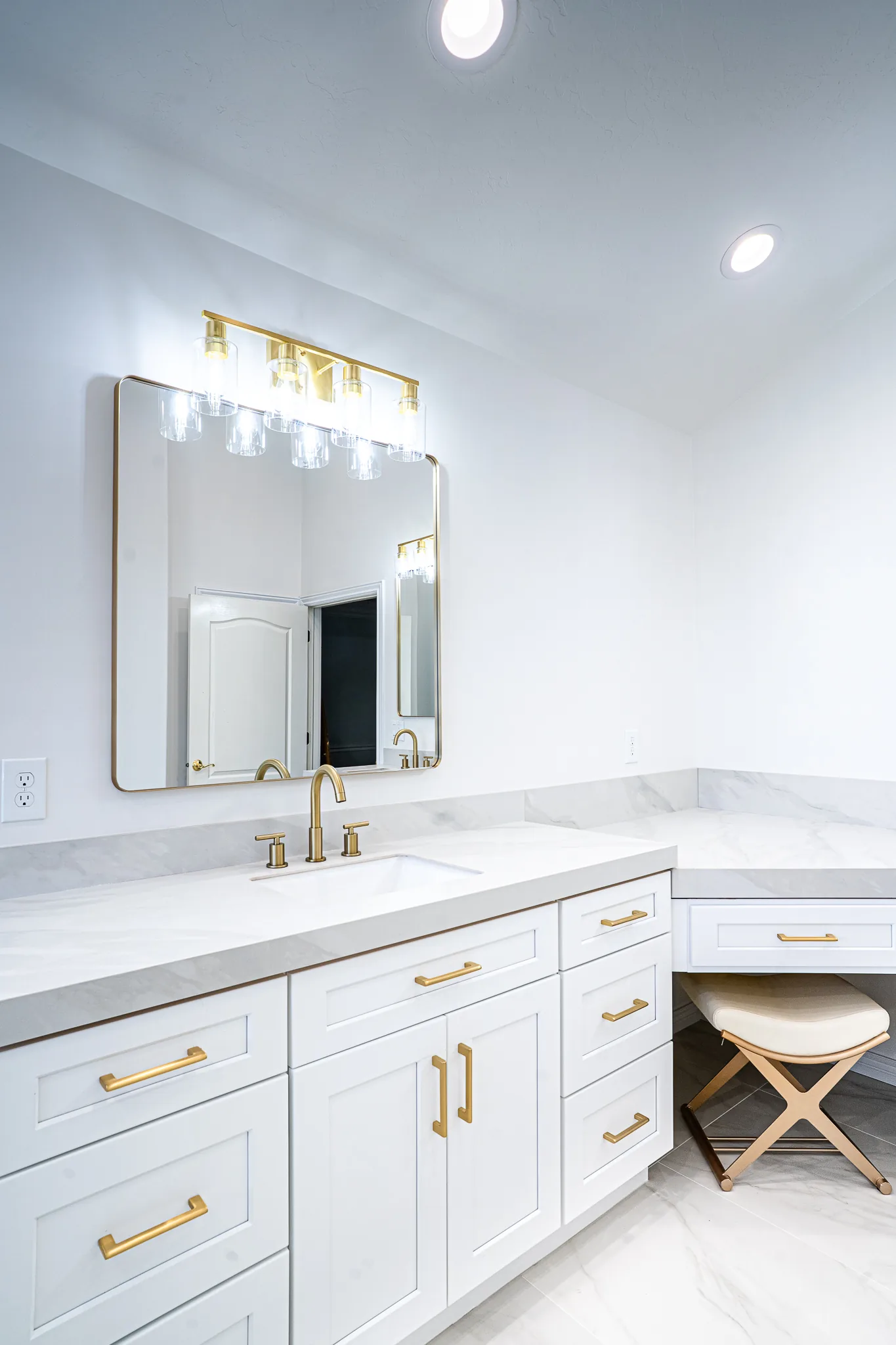 Freestanding tub under plantation shutters in a white marble master bath