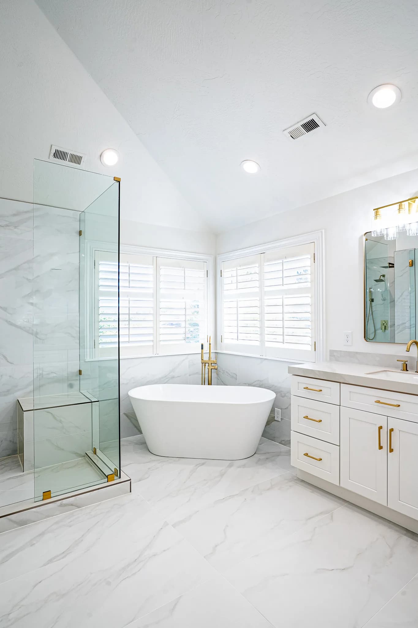 Master bathroom vanity with gold pulls, a marble counter, and a makeup desk