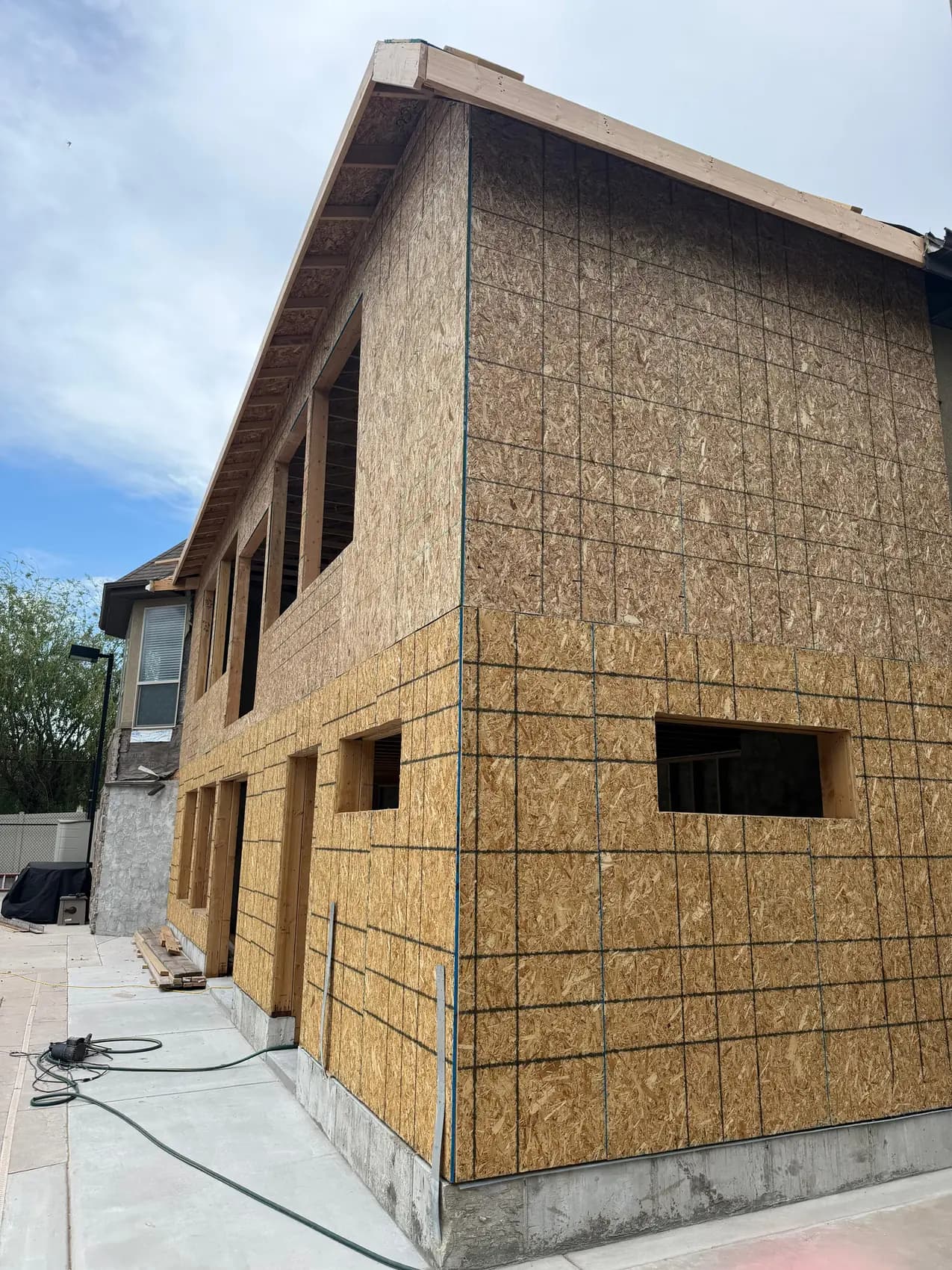 Two-story home addition sheathed in OSB, side view